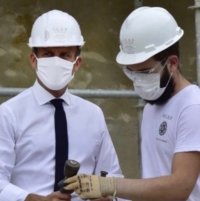 Les ouvriers de la SGRP sont tous profondément touchés et émus ; le Président de la République Emmanuel Macron a souhaité taper sur une pierre et a emprunté les outils d'un tailleur de pierre. / Photo DDM, SGRP, DR.